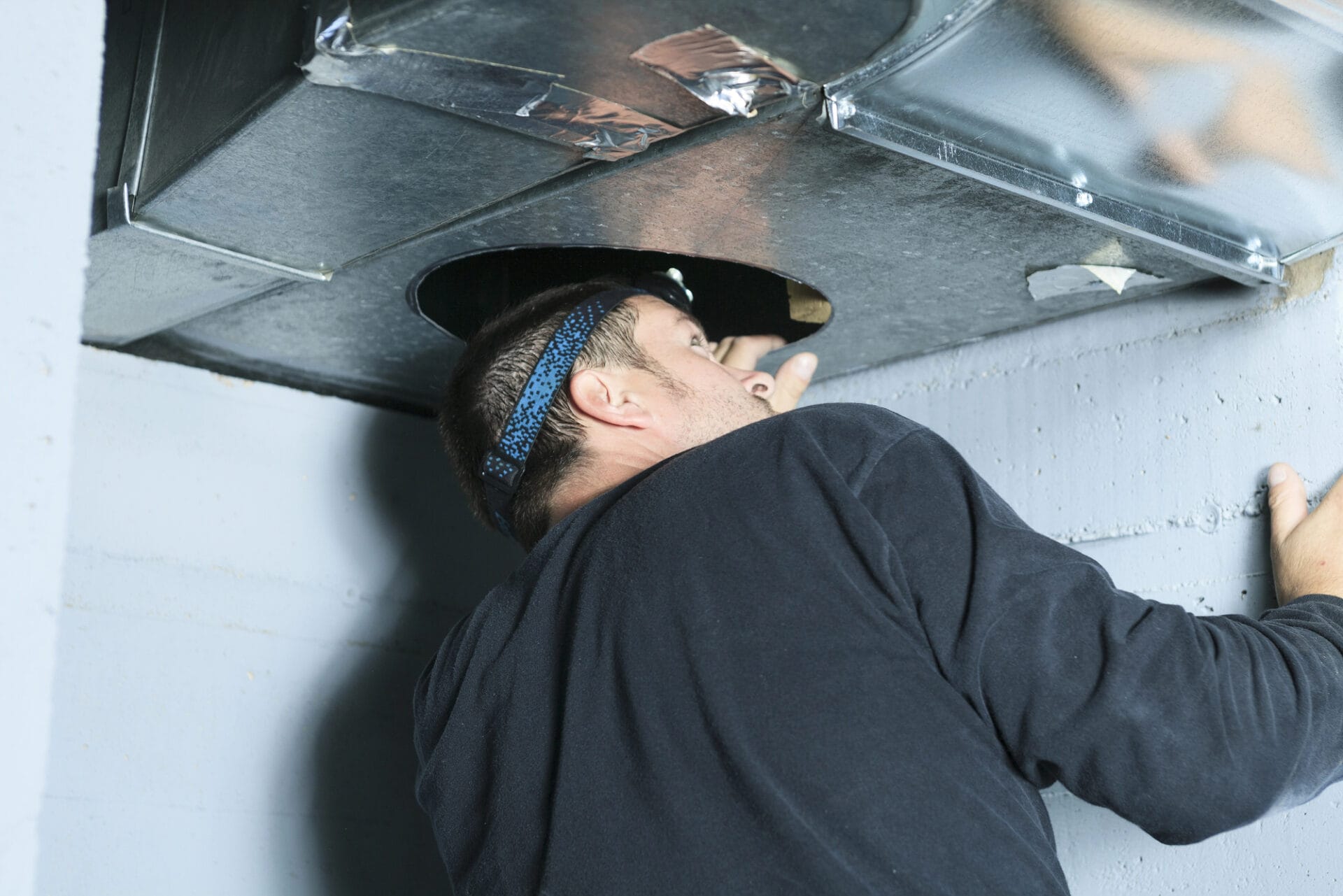 Technician installing air duct system.