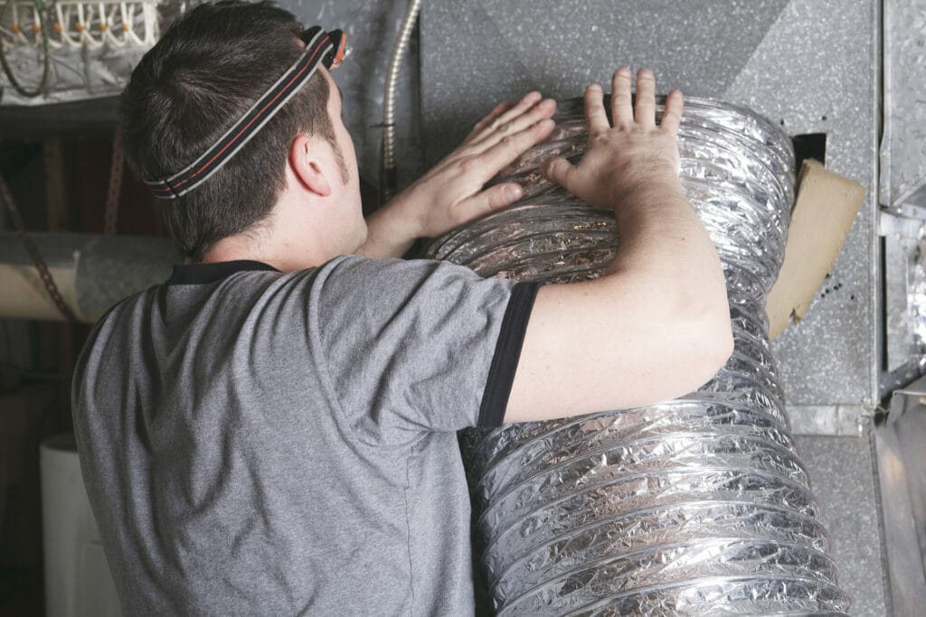 Technician installing flexible air duct system.